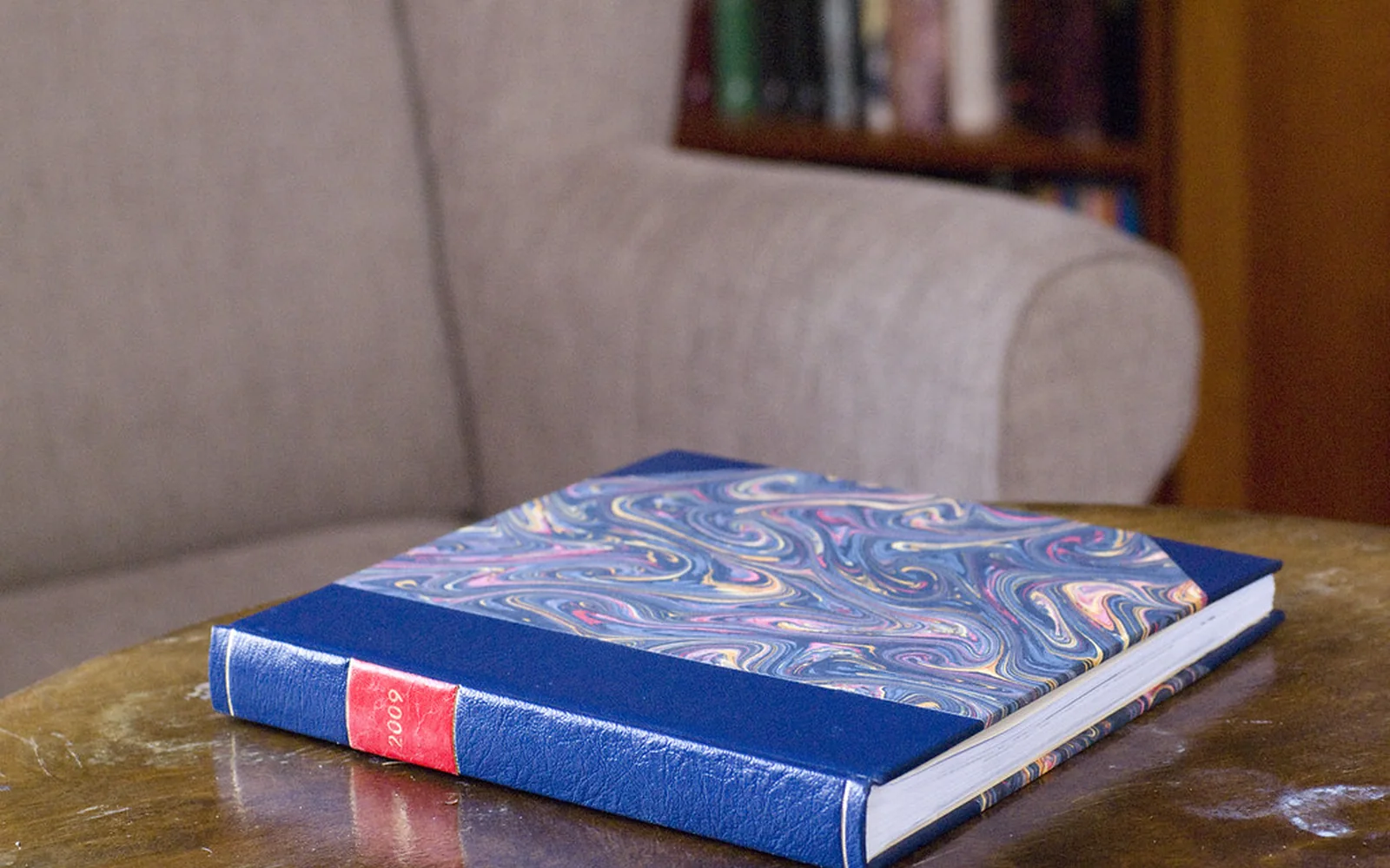 Álbum de fotografías encuadernado a mano sobre una mesa.