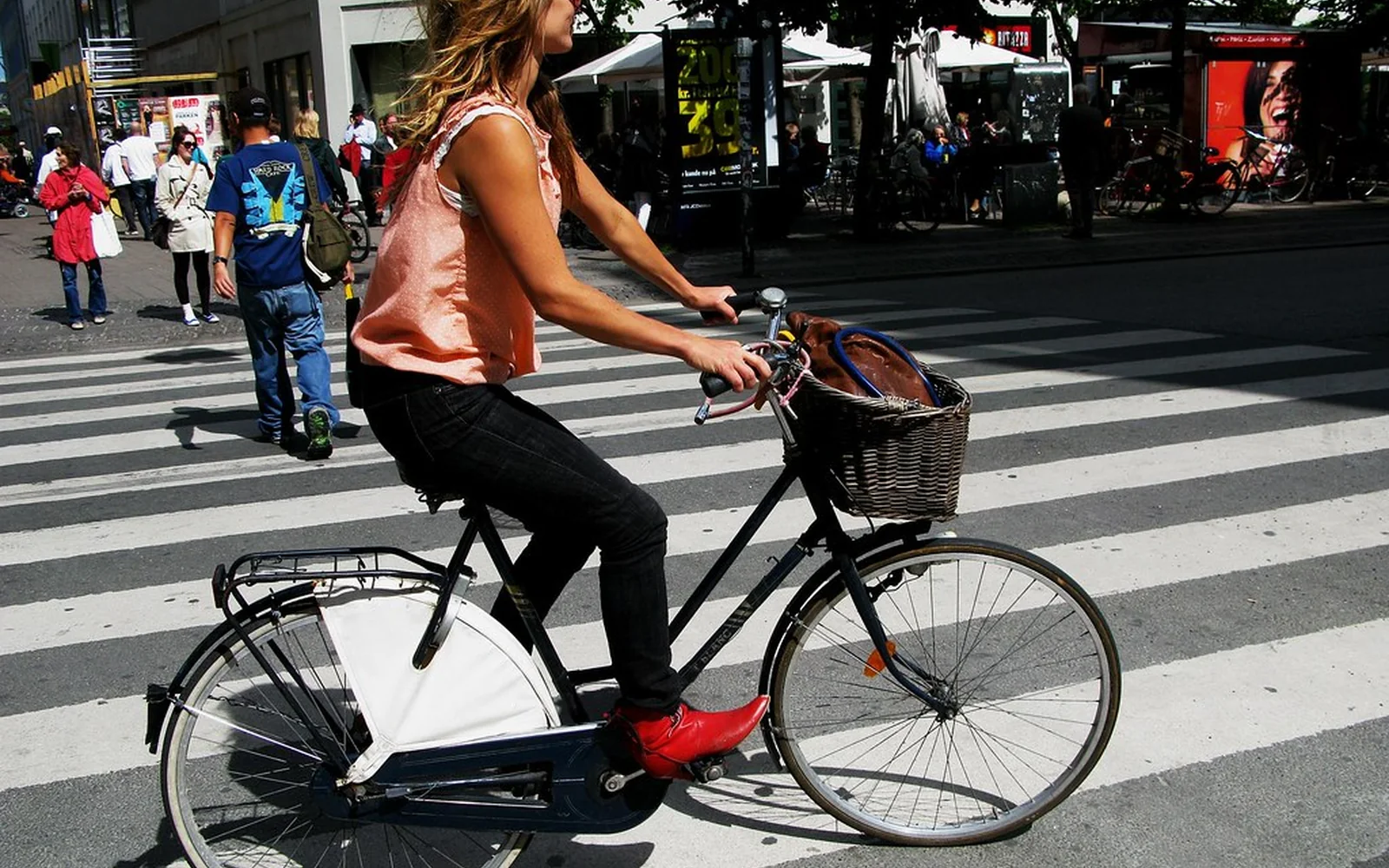 Una ciclista cruza una calle urbana junto a varios peatones.
