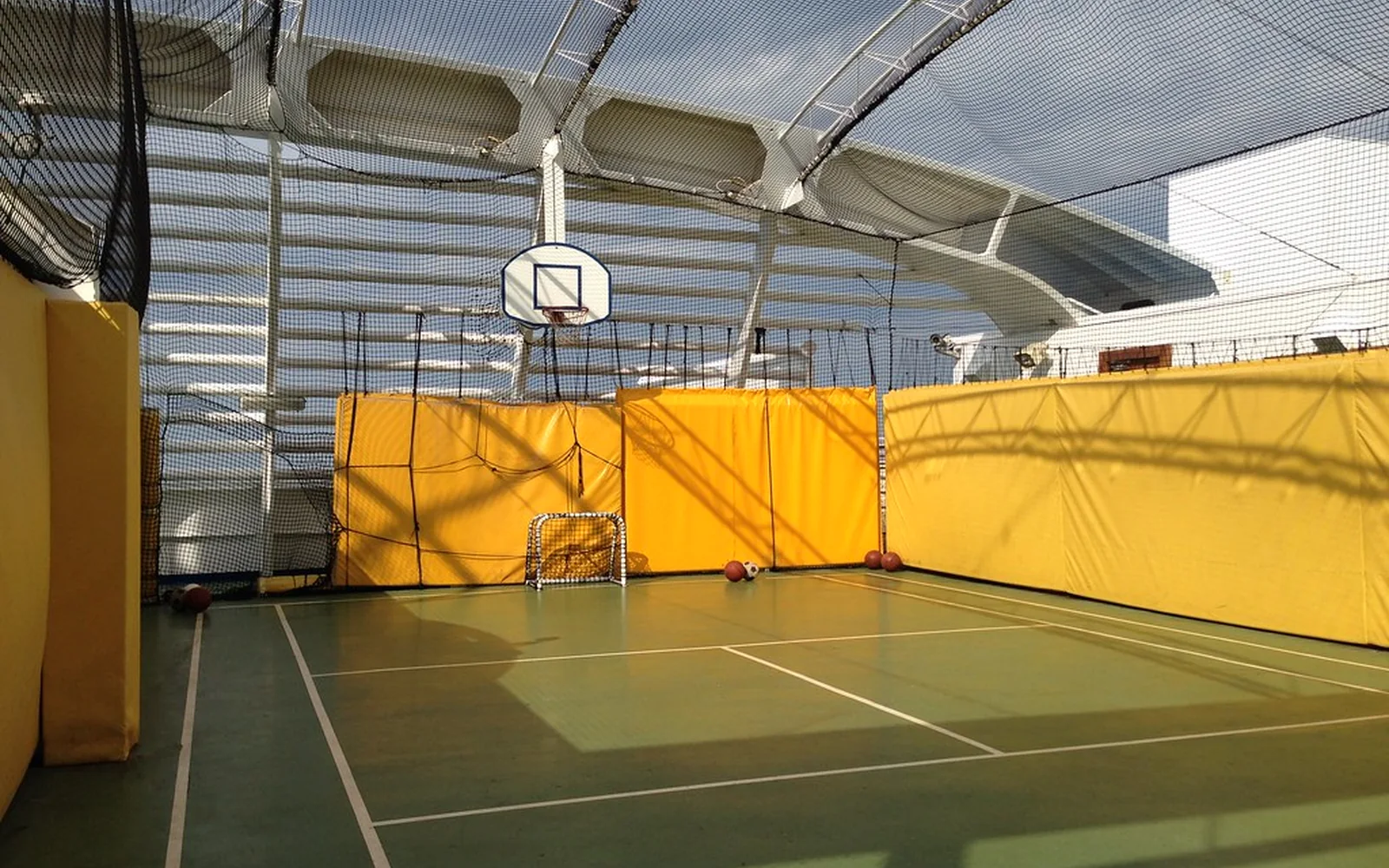 Cancha deportiva cubierta y vacía en un polideportivo de barrio.