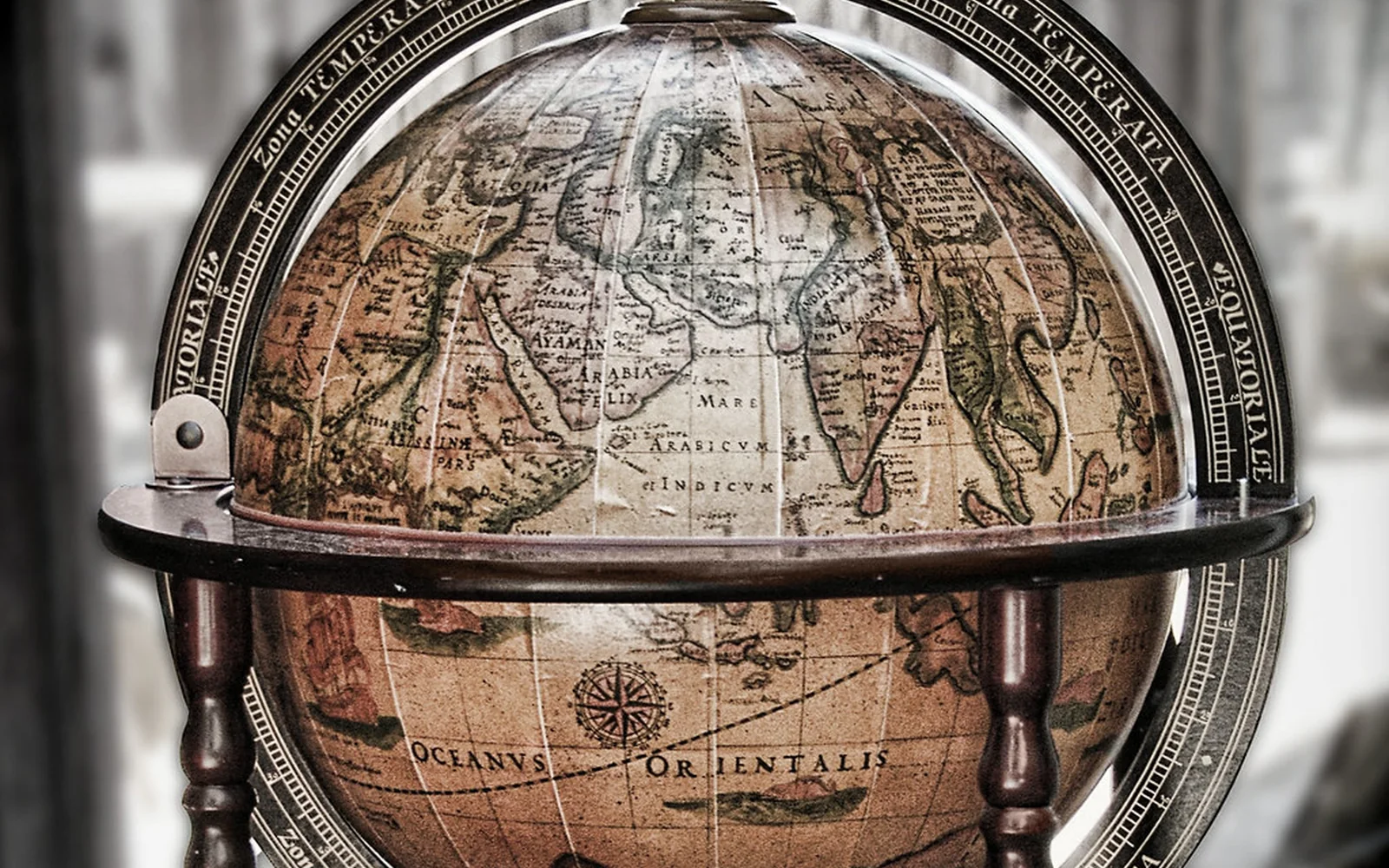 Globo terráqueo antiguo con un mapa histórico en tonos sepia.