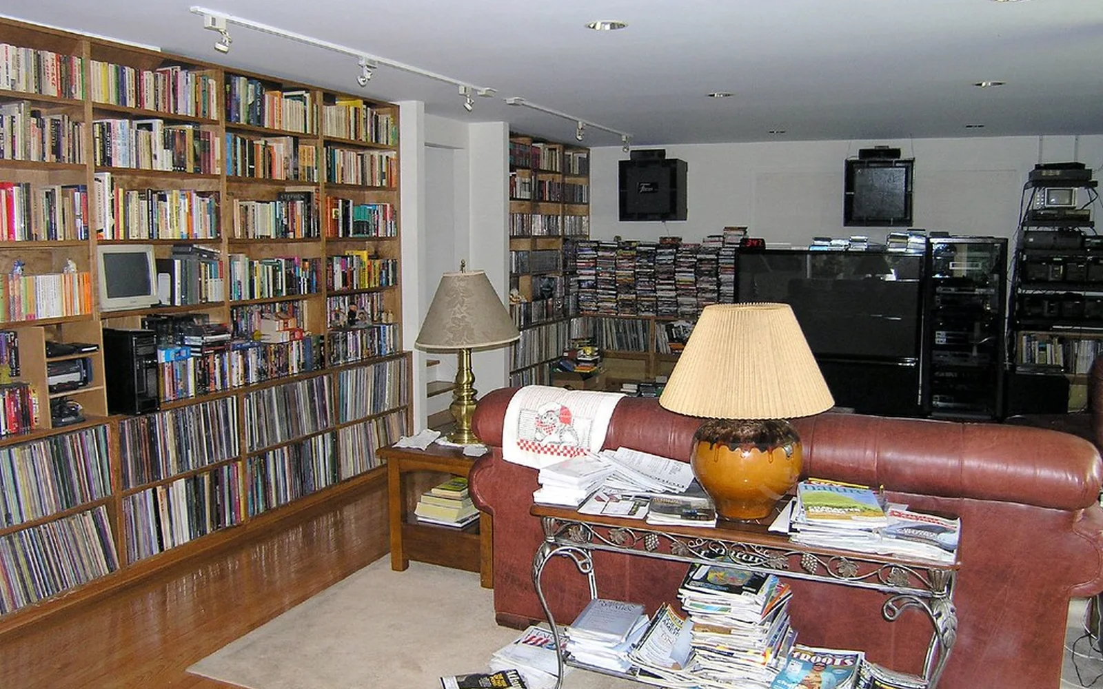 Salón doméstico rodeado de estanterías llenas de libros y discos.