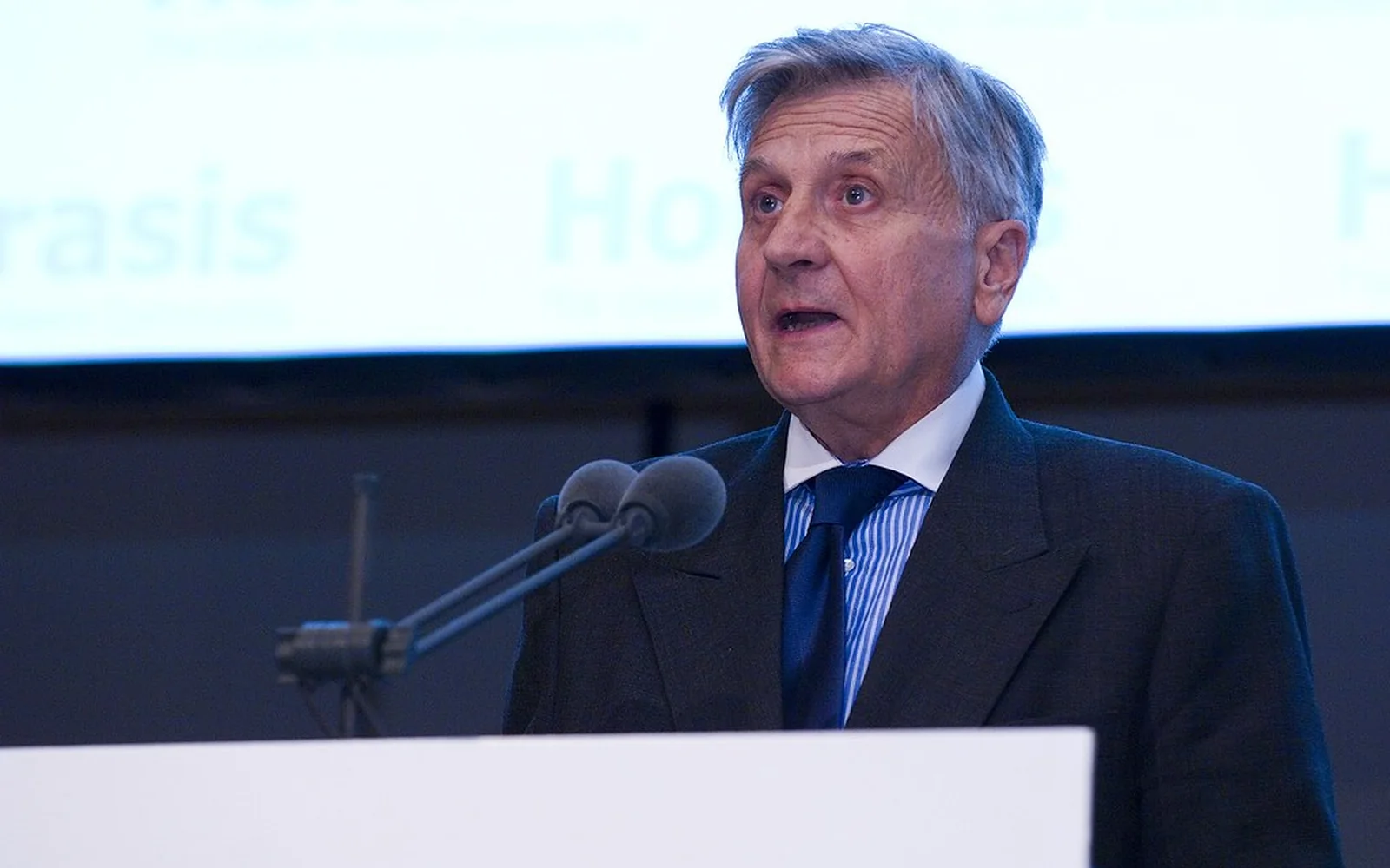 Directivo interviene desde un atril durante una reunión profesional.
