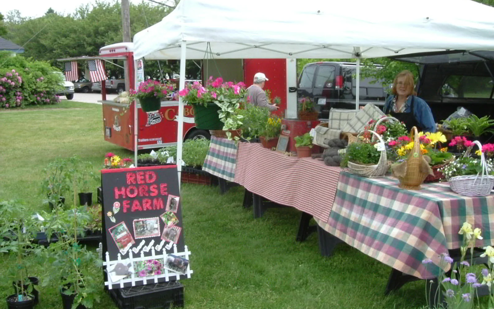 Puesto de un mercado de productores decorado con flores y verduras.